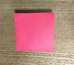 更に半分に折った赤い折り紙