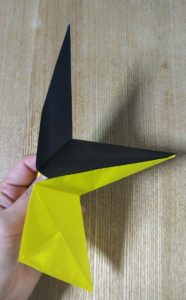 折った1枚の黄色い折り紙と黒い折り紙