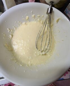 常温のクリームチーズに砂糖、小麦粉、全卵を入れてハンドミキサーで混ぜたものが入った白いボウル