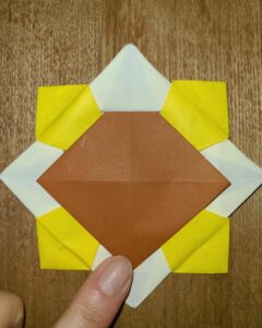 黄色い折り紙で作った折り紙の花と茶色い折り紙で作ったひまわりの中心